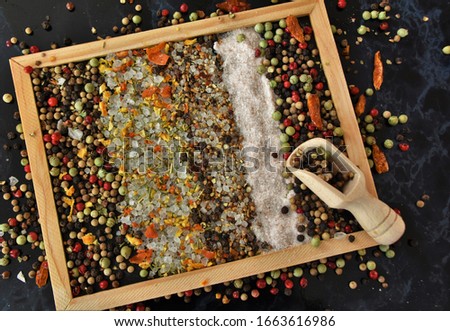dry seasoning, peppercorns and salt on a black board
