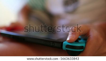 
Child hands closeup playing video-game with joystick