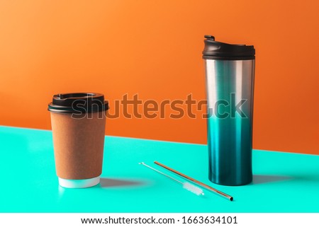 Reusable metal and paper coffee cup, eco friendly straw, zero waste concept, color block background