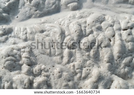 Closeup of soft white sea foam on coast 