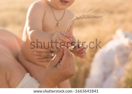 the mother gives the child an ear of wheat