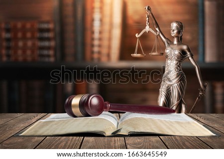 Book and wooden gavel on table. Justice concept