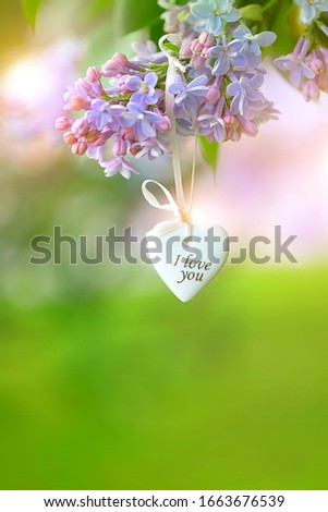 lilac flowers and heart on green natural abstract background. text "I love you". gentle image for Valentine's Day, Mothers Day, 8 march. heart - symbol of love, romance. spring season. copy space