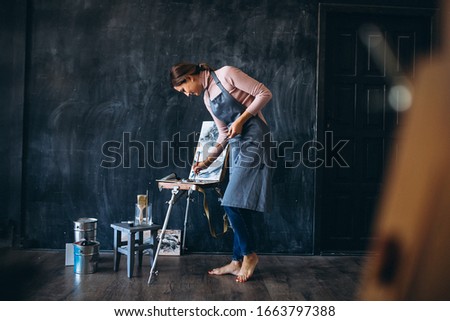 Young woman artist painting a beautiful picture