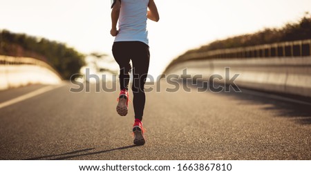 Fitness woman running on city road Royalty-Free Stock Photo #1663867810