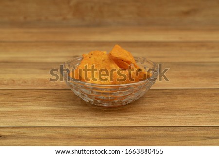 Plate with tasty nachos with wooden background