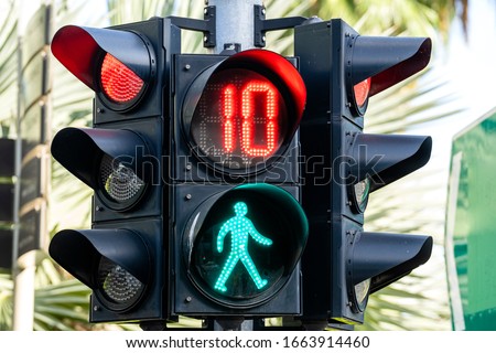 Traffic lights of a city with green figure of pedestrian on the street in Singapore, close up