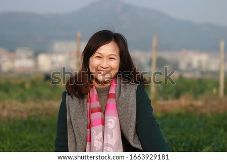The woman sitting on the ground smiling at the camera Royalty-Free Stock Photo #1663929181
