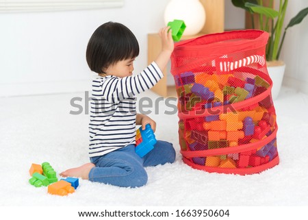 Kid clearing toy blocks, 2 year old girl