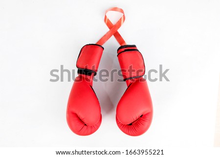 Pair of boxing gloves shaped like a ribbon and attached to the red ribbon itself, isolated in white background