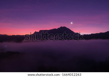 Beautiful harmony color sunrise landscape scenery with sunlight and fog and Mount Kinabalu as background in Guakon, Sabah, Malaysia