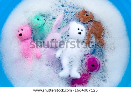 Soak rabbit dolls with  bear toys in laundry detergent water dissolution before washing.  Laundry concept, Top view