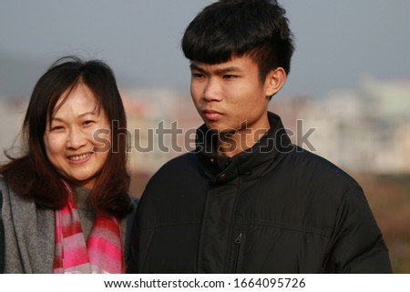 The mother leaned happily by her son's side