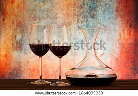 Glasses with red wine and decanter on table