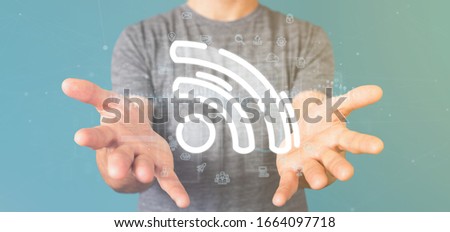 View of a Businessman holding a wifi icon with data all around