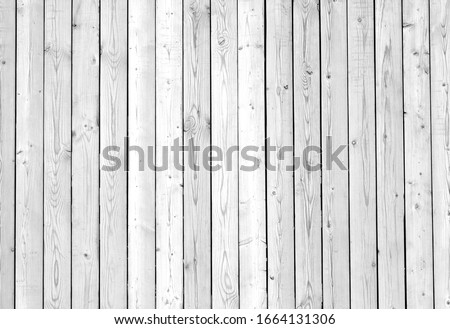 Fence made of wooden planks in black and white. Abstract background and texture for design.