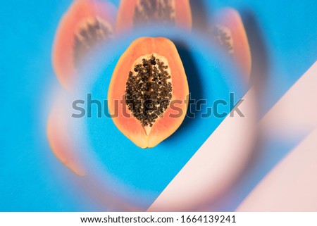 Flat lay minimal papaya fruit with kaleidoscope filter effect. Fruit styled with banana leaf and tropical greenery. Fresh, juicy, orange papaya with visible seeds. Healthy superfood summer vibes.