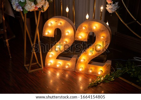 Happy 22 years old celebration. Numbers 22 carved from wood with light. Interior decoration for a birthday. Royalty-Free Stock Photo #1664154805