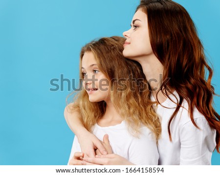 Blue background happy mom hugs little daughter