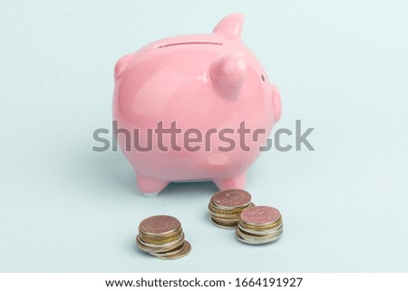 Piggy bank with coin pile on blue  background, space for text. Finance, saving money. Business to success and saving for retirement concept