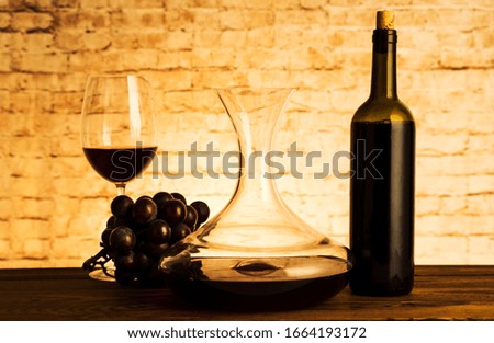 Decanter with red wine and glasses on table
