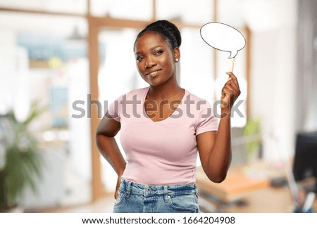 party props, photo booth and communication concept - happy african american young woman holding blank speech bubble over office background