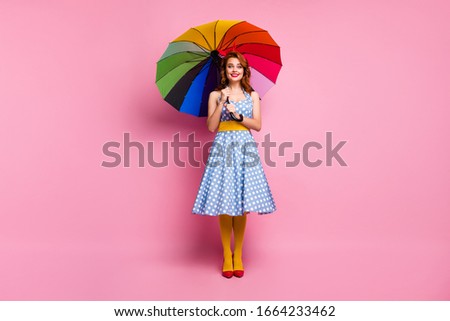 Full length photo positive cheerful lady enjoy fall spring rainy meteorology weather hold colorful bright parasol wear polka-dot yellow stockings red footwear isolated pink color background