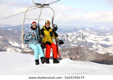 People using chairlift at mountain ski resort. Winter vacation Royalty-Free Stock Photo #1664240674