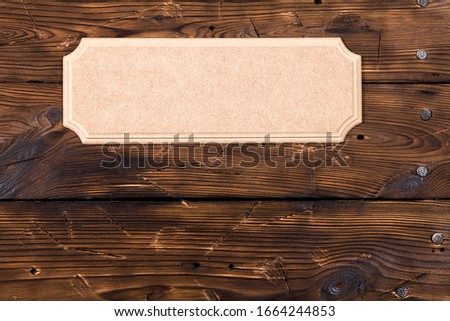 A light brown rustic tablet lies on an old wooden wall