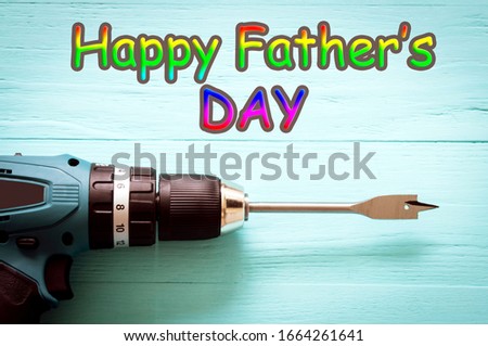 screwdriver close-up on a turquoise wooden background, top view, vignetting and toning images, happy father's day card