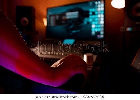 Hands controlling or mixing electronic music track.