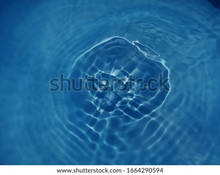 The​ abstract​ of​ surface blue water​ reflected​ with​ sunlight for​ background. The​ pattern​ of surface​ blue​ water in the​ deep sea for​ blue​ background​