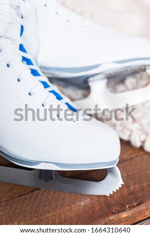 Close up view. New white figure skates on a wooden boards.