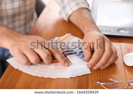 Male designer with color palettes in office, closeup