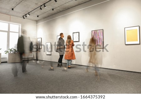 Exhibition in modern crowded art gallery Royalty-Free Stock Photo #1664375392