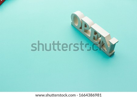 white color "open" sign with turquoise blue background.