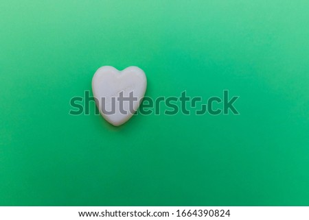 Minimalistic green background with white heart with text I love you. Picture with copy space