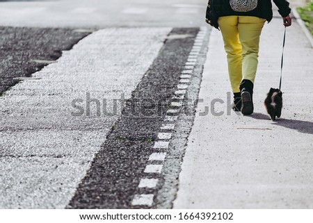 Person with yellow pants walking on the road