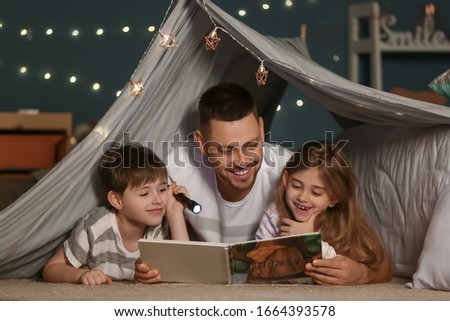 Father and his little children reading bedtime story at home Royalty-Free Stock Photo #1664393578