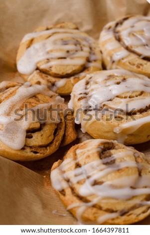 Cinnamon rolls with icing on brown paper