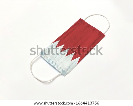 Concept. Disposable medical surgical face mask with Bahrain country flag superimposed on it, on white background. Protection against Covid-19 coronavirus outbreak.