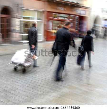 Busy city people going along the street. Intentional motion blur. Defocused image