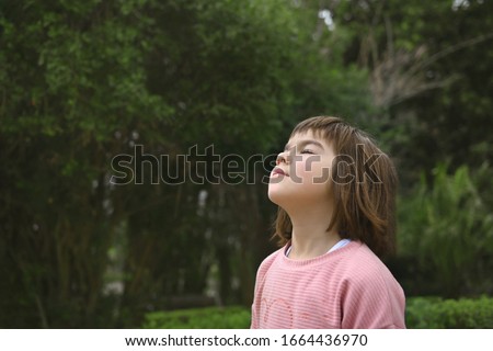 7 year old cute little girl of Asian appearance in the park breathes fresh air, ecology concept Royalty-Free Stock Photo #1664436970