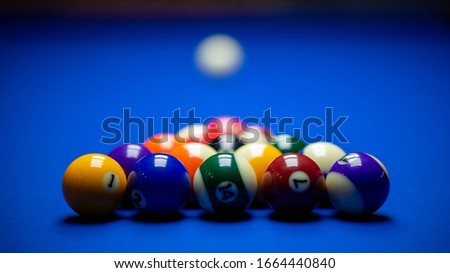 Colorful balls on a blue pool table. Set up and ready to play. Selective focus. Royalty-Free Stock Photo #1664440840