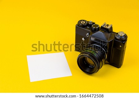 Flat lay film camera isolated on yellow background. Copy space