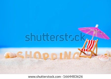 Summer holiday decoration with wooden text, beach chair and sea shall on white sand beach over blue background,