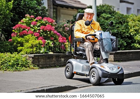 An elderly person drives an electric vehicle Royalty-Free Stock Photo #1664507065