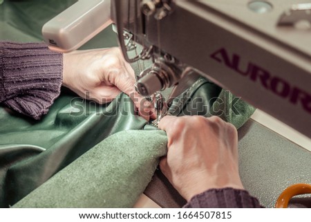 Sewing Process - Women's hands behind her sewing genuine leather