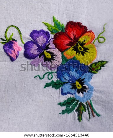 Embroidered flowers on the fabric. Ukrainian folk hand embroidery. On white background.