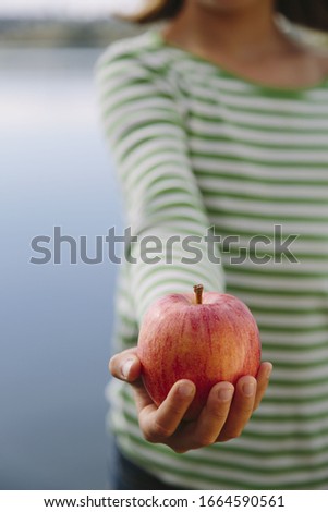 Detail of nine year old girl holding organic apple